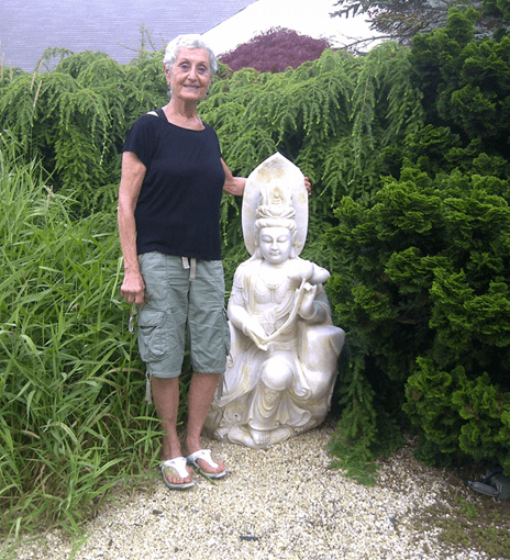 An old woman next to a statue